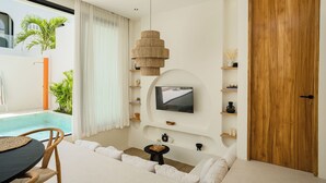 Una sala de estar moderna con vista a la piscina, un televisor montado en la pared y una puerta de madera.