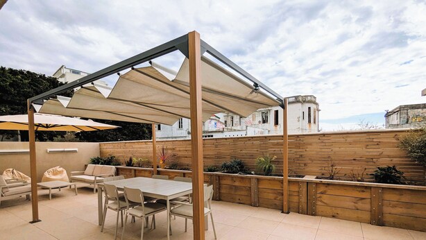 An outdoor patio with a table and chairs, a wooden fence, and potted plants. - Penthouse with large terrace, near beaches (Toulon)