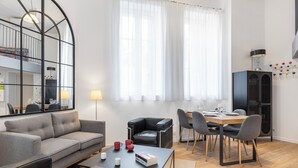 A modern living room with a sofa, coffee table, and dining area. - Cosy T2 in Cannes (Cannes)