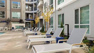 Alberca al aire libre, sombrillas en la alberca y camastros