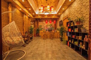 Un interior acogedor con techo de madera, una silla colgante, una zona de bar y estantes con diversos objetos.