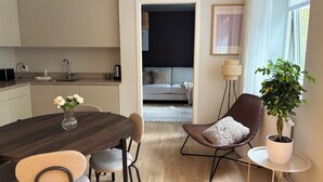 Un espacio habitable moderno con comedor, cocina y una zona de estar acogedora con un sofá y una silla.