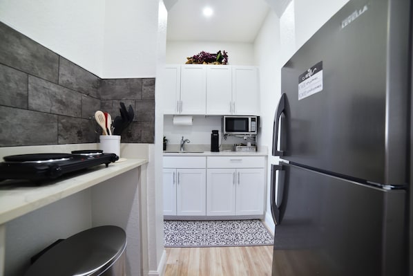 Enjoy cooking in this well-equipped kitchen with a refrigerator, microwave, and coffee machine.