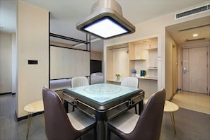 A modern dining area with a glass-top table, cushioned chairs, and a pendant light. - New Tangji Hotel (Taiyuan South Neihuan Street Jianshe South Road) (Taiyuan)