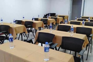 A conference room with tables and chairs, water bottles on tables, and a door in the background. - New Tangji Hotel (Taiyuan South Neihuan Street Jianshe South Road) (Taiyuan)