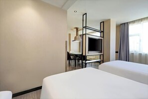 A hotel room with two beds, a TV, a desk with a chair, and a window with curtains. - New Tangji Hotel (Taiyuan South Neihuan Street Jianshe South Road) (Taiyuan)