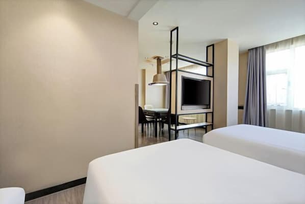 A hotel room with two beds, a TV, a desk with a chair, and a window with curtains. - New Tangji Hotel (Taiyuan South Neihuan Street Jianshe South Road) (Taiyuan)