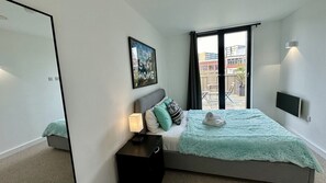 Relax in a serene space with a large bed, nightstand, and framed artwork.