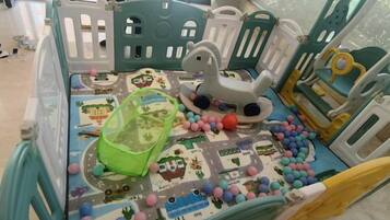 A play area with a play mat, balls, and a toy car.