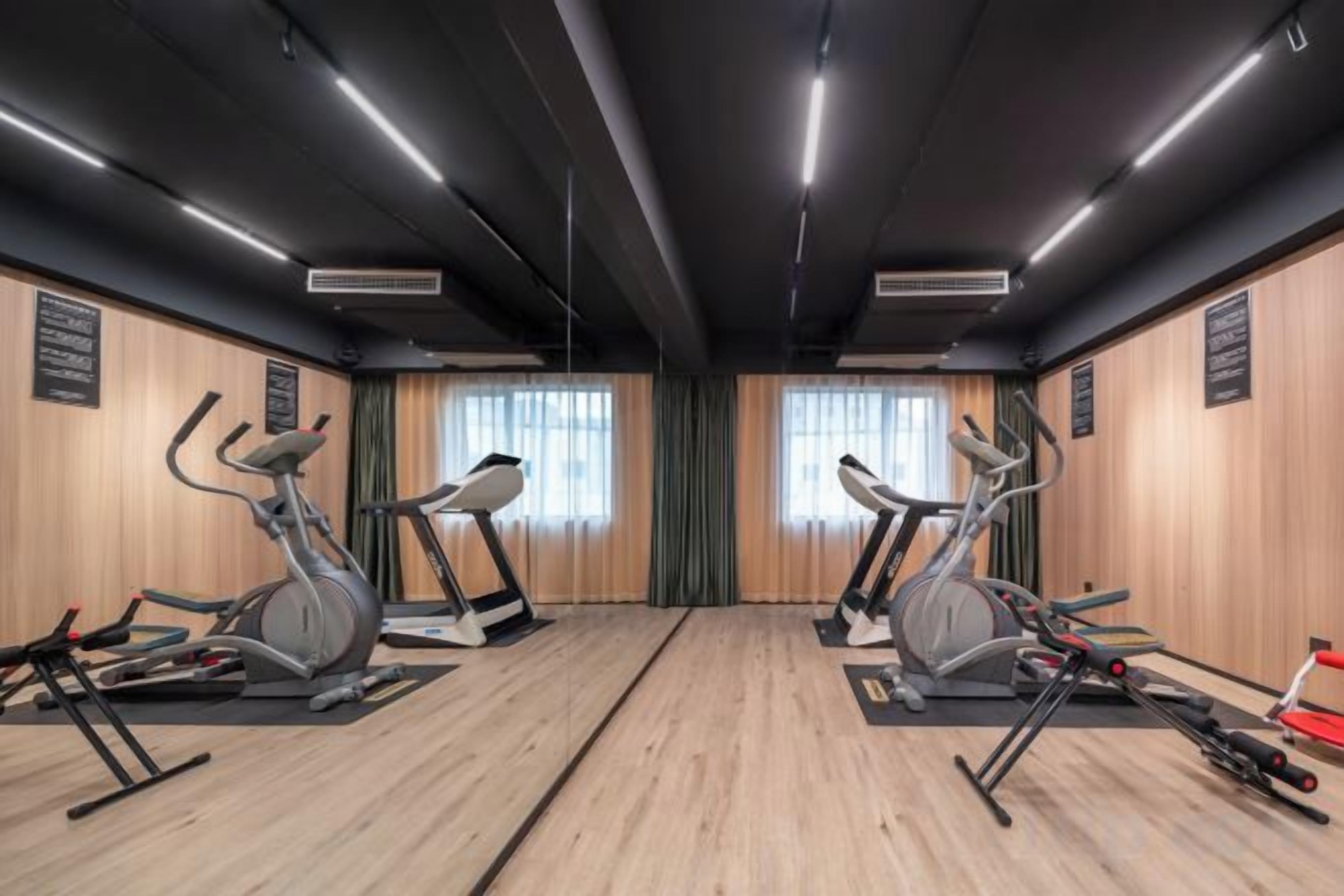 A gym with treadmills, stationary bikes, and exercise equipment.