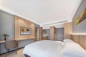 A modern hotel room with a bed, a desk, a chair, and a wall-mounted TV. - Manju Hotel Railway Station Jinhua (Jinhua)