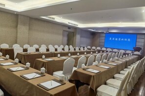 A conference room with rows of tables, chairs, and a projection screen. - Manju Hotel Railway Station Jinhua (Jinhua)