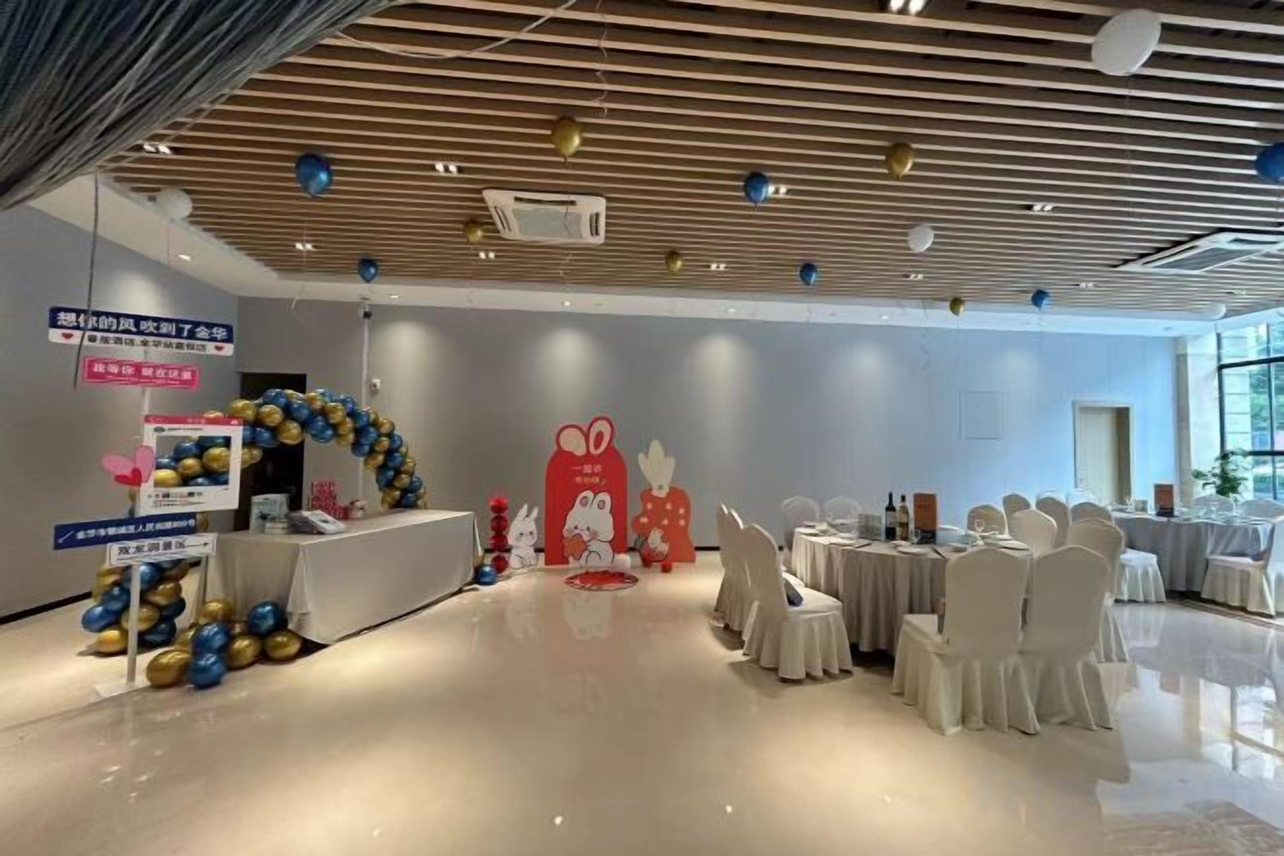 Una habitación amplia con piso pulido, una mesa de recepción y un ventanal grande.