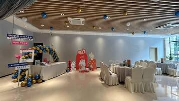 Una habitación amplia con piso pulido, una mesa de recepción y un ventanal grande.