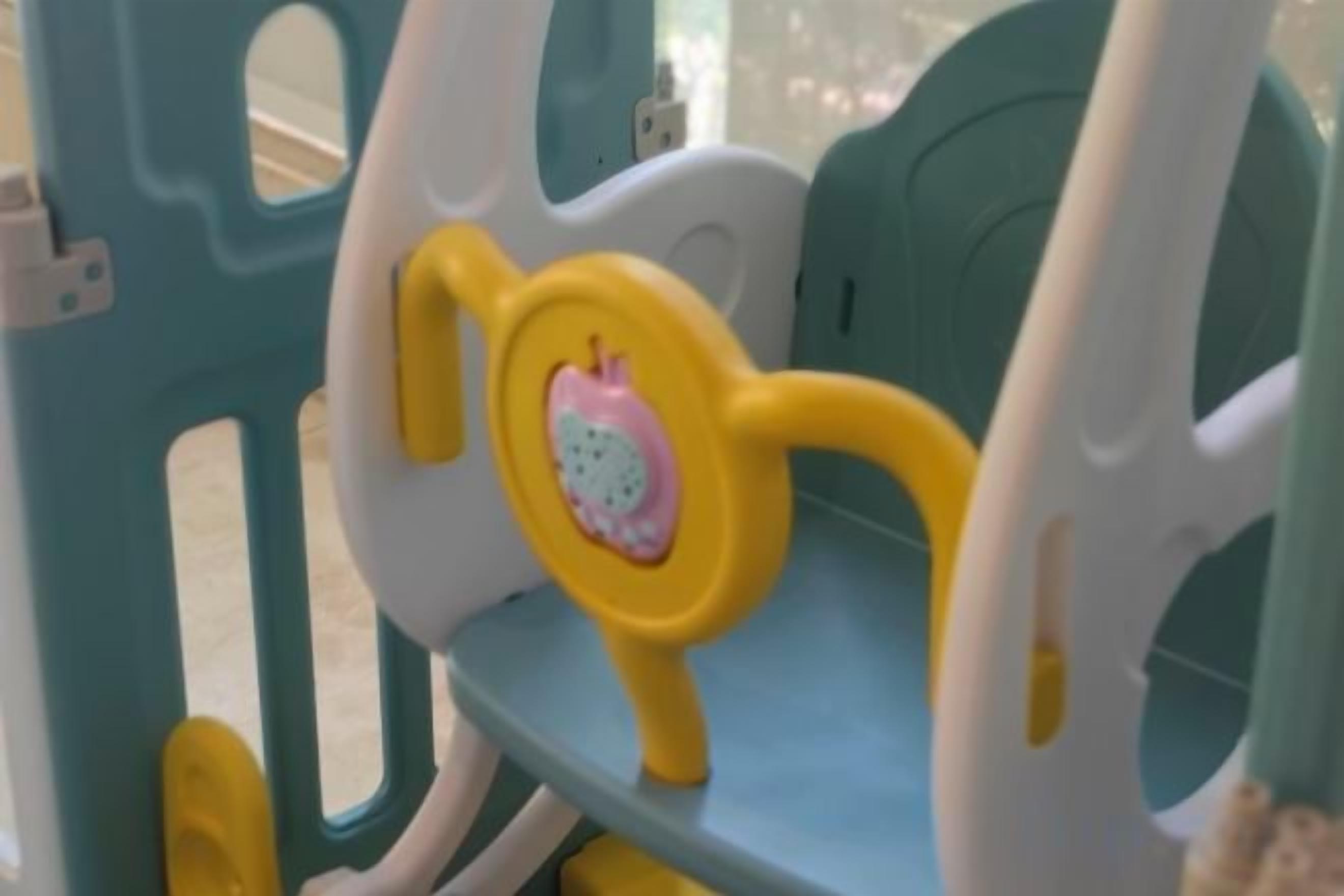 A part of a child's play structure with a seat and a handle.