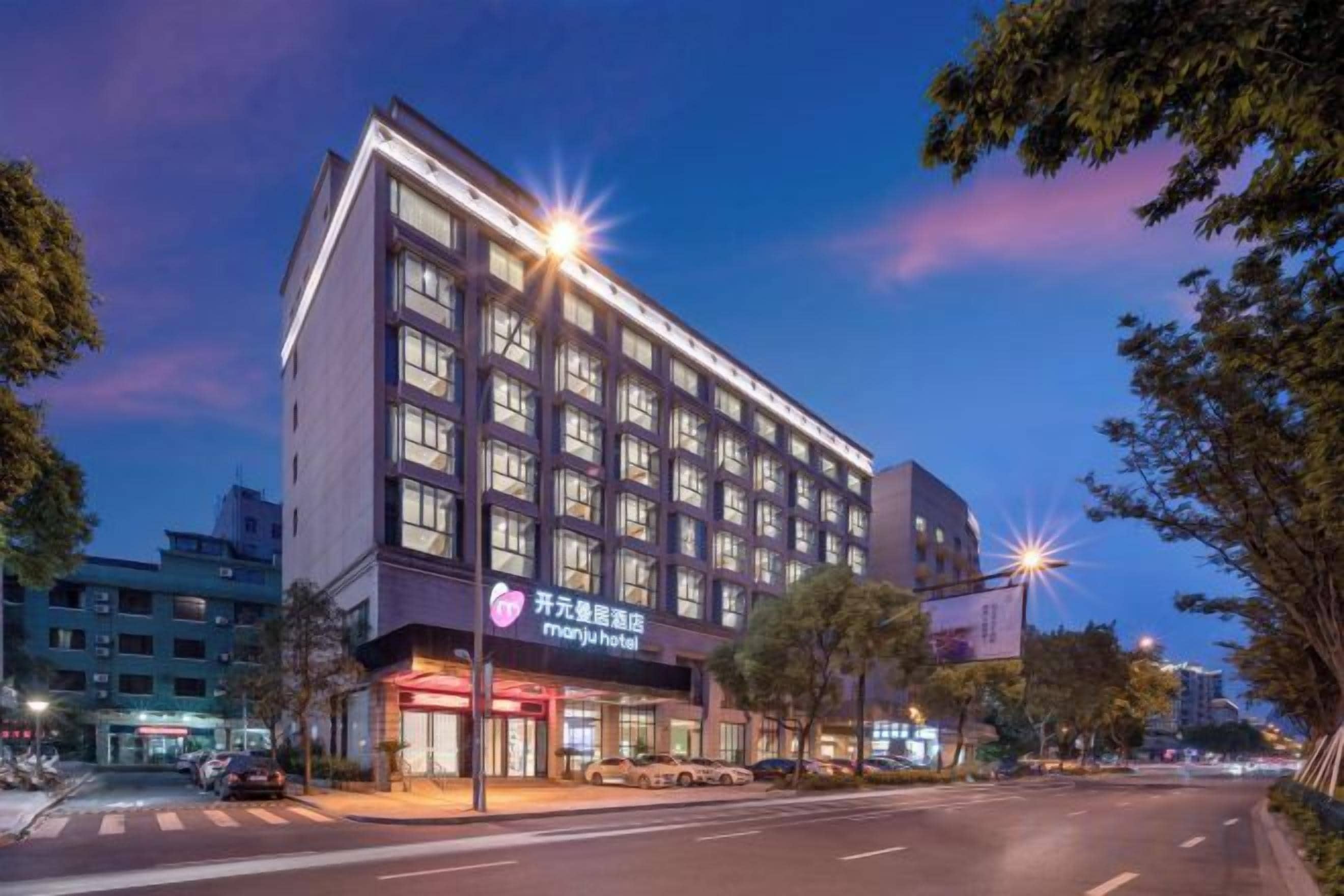 A multi-story hotel with a modern facade, large windows, and a visible entrance with signage.