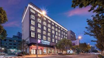 A multi-story hotel with a modern facade, large windows, and a visible entrance with signage.
