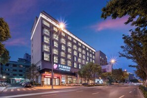 Un hotel de varios pisos con fachada moderna, grandes ventanales y una entrada visible con señalización.