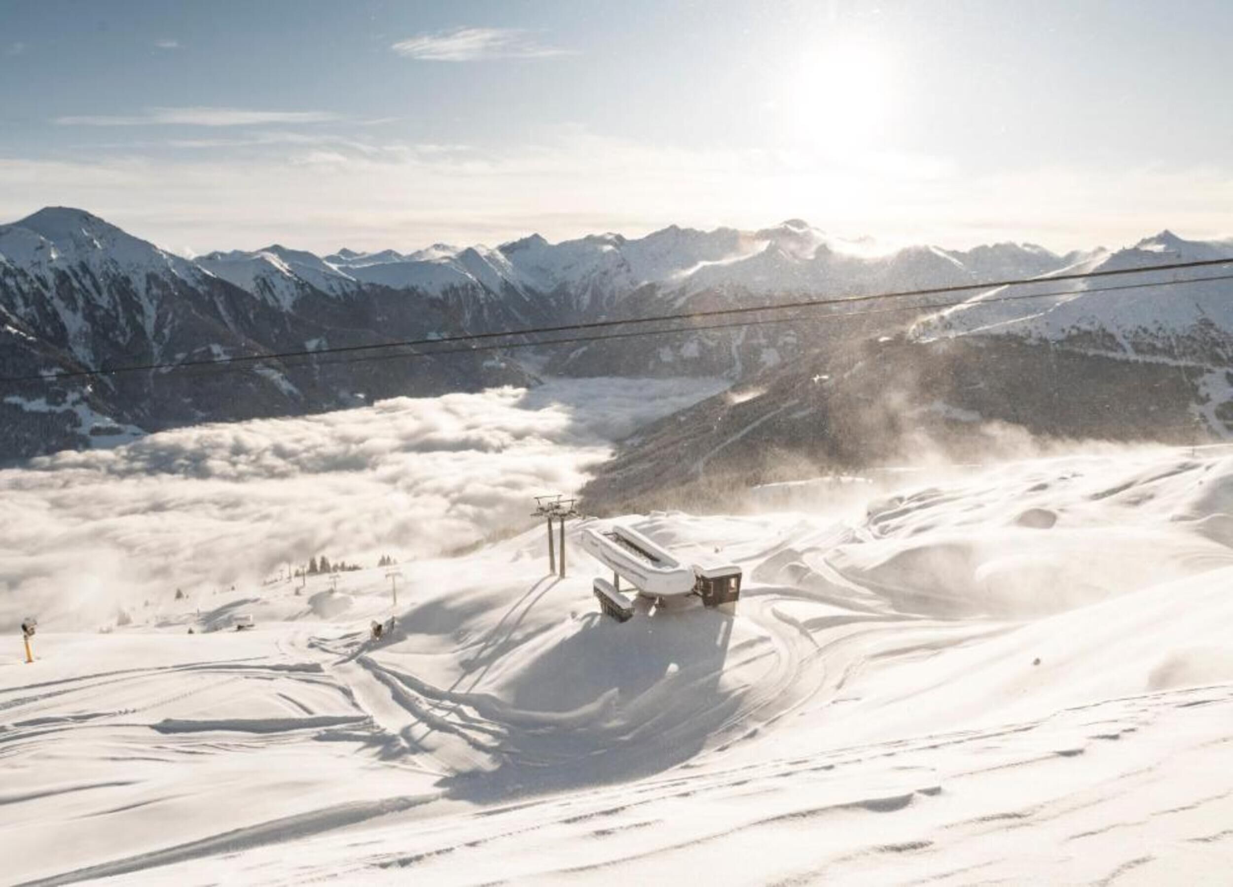 A ski lift in a snowy mountainous area with a clear sky.