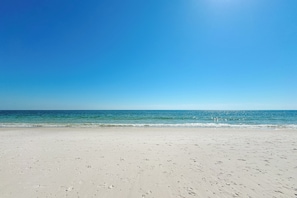 A beach with a clear sky and calm sea.