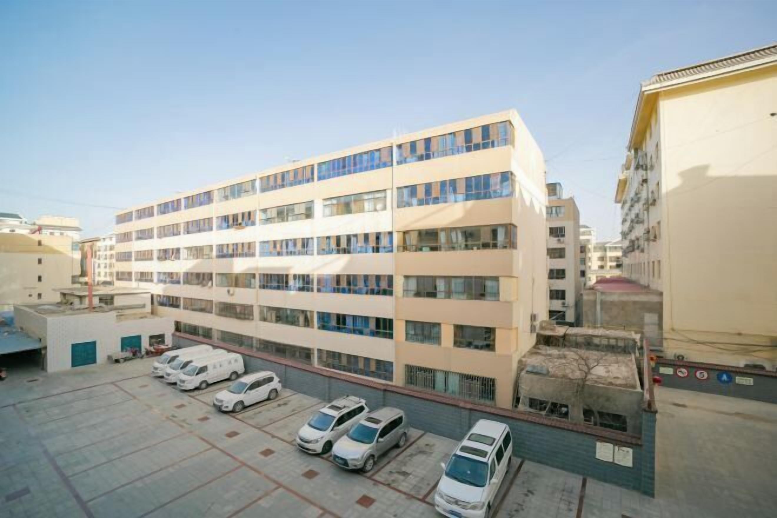 A multi-story building with a parking lot in front.