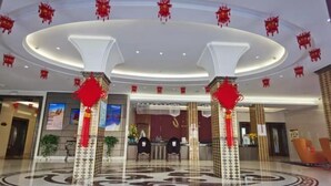 A spacious lobby with a central reception desk, modern lighting, and decorative red lanterns. - Dunhuang Carnival International Hotel (Shazhou Night Market) (Dunhuang)