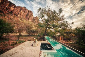 Una piscina amb vistes a penya-segats rocosos i vegetació escassa.