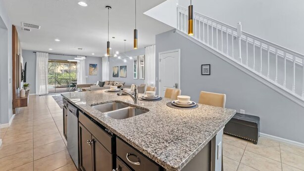 A modern kitchen with granite countertops, a central island, and pendant lighting. - FL- 1844 GOBI DR (Kissimmee)
