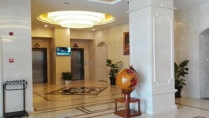 A lobby with a marble floor, a large chandelier, and a globe on a stand. - GreenTree Inn (Shanghai Jiangyue Road Metro Station) (Shanghai)
