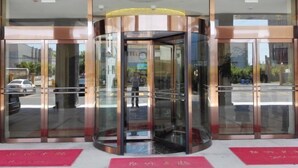 A revolving door with glass panels and a metallic frame, leading to a building entrance. - GreenTree Inn (Shanghai Jiangyue Road Metro Station) (Shanghai)