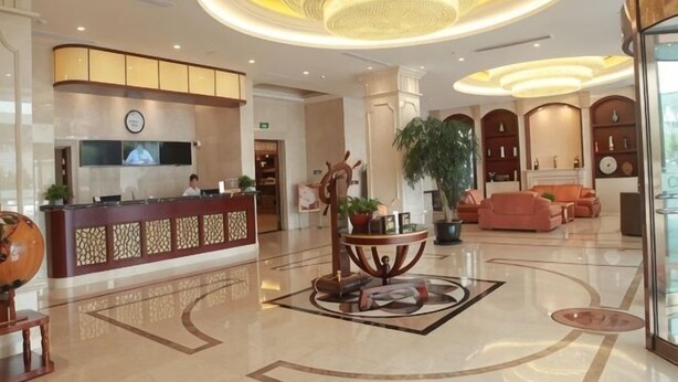 A hotel lobby with a reception desk, seating area, and a large chandelier. - GreenTree Inn (Shanghai Jiangyue Road Metro Station) (Shanghai)