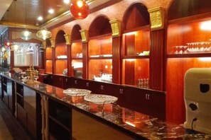 Eine Bar mit einer langen Theke, verschiedenen Sitzmöglichkeiten und einer dekorativen Rundbogenzarge.