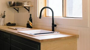 A kitchen with wooden cabinets, a black faucet, and a window with a view.