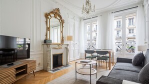 Un salon spacieux avec une cheminée, un téléviseur et un canapé.