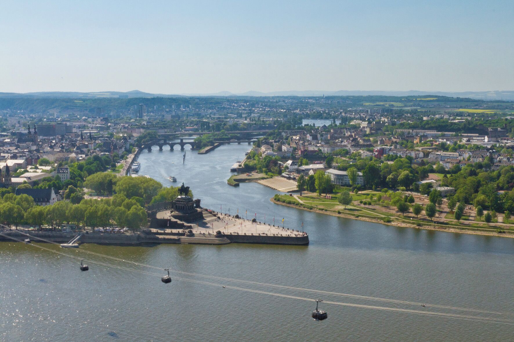 A river with a bridge, a statue, and a boat.