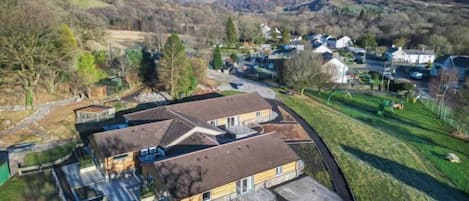 Un quartier résidentiel avec des maisons, une allée et une colline en arrière-plan.