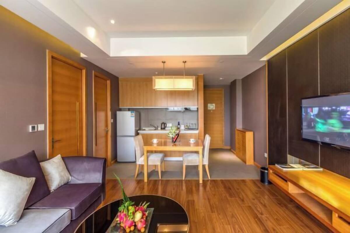 Una sala de estar moderna con un sofá, una mesa de comedor y una cocina al fondo.