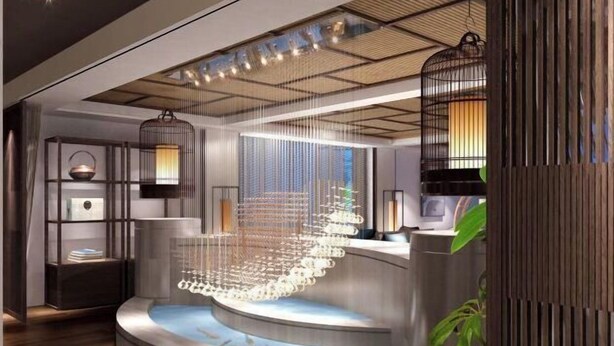 A modern interior with a central water feature, a hanging light fixture, and a wooden accent wall.