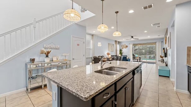 A modern kitchen with a large island, granite countertops, and stainless steel appliances.
