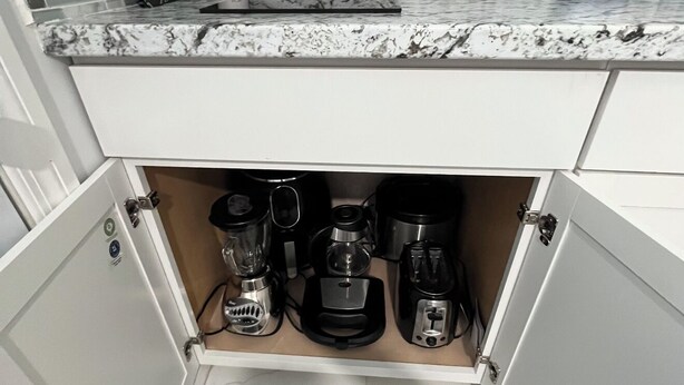Une cuisine équipée d’un plan de travail en marbre, d’une machine à café, d’un mixeur et d’un grille-pain.