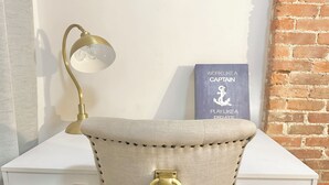 Un bureau avec une lampe, une chaise ornée d’un anneau en laiton, et un livre intitulé « Travaillez comme un capitaine, amusez-vous comme un pirate ».