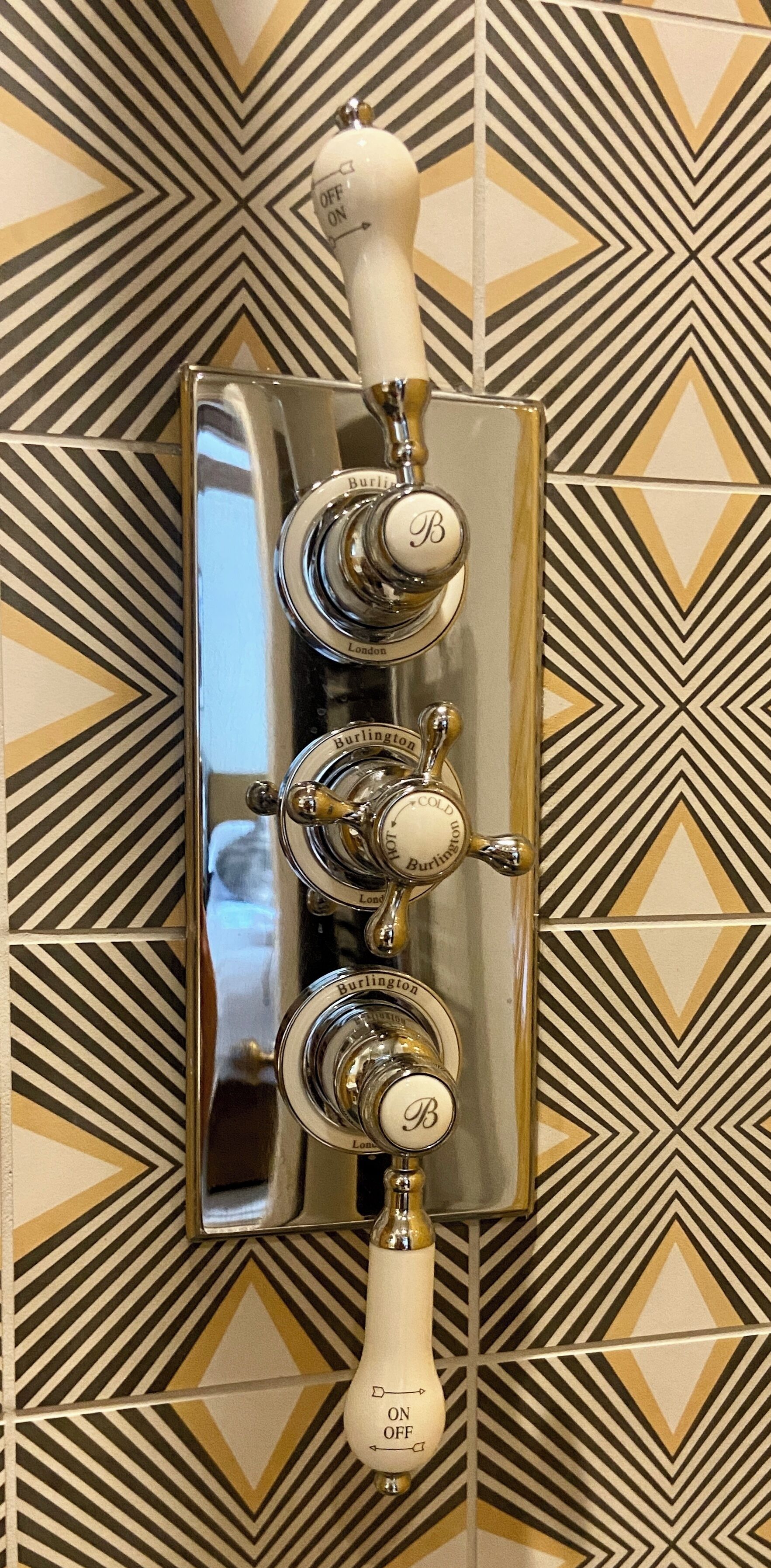 Un baño con una lámpara de pared y un espejo.