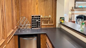 A kitchen with wooden cabinetry, a stainless steel dishwasher, and a black countertop. - Dog-Friendly Lakehouse: Dock + Serene Views (Burnet)