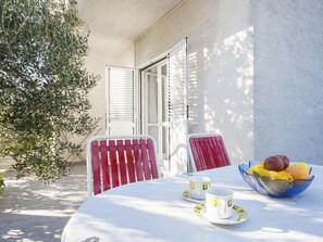 An outdoor table with two chairs, a bowl of fruit, and two cups with saucers. - Apartment in Sibenik Near Adriatic Beaches (Sibenik)
