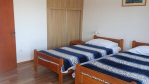 A room with two wooden beds, a wardrobe, and a framed picture on the wall. - Apartment by Adriatic Sea Near Sibenik (Sibenik)