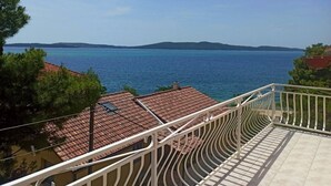 A balcony with a view of the sea and distant hills. - Apartment by Adriatic Sea Near Sibenik (Sibenik)