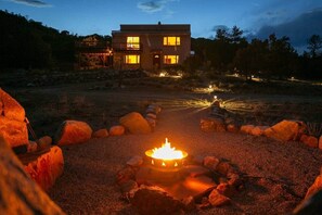 A house with a fire pit in the foreground, surrounded by rocks. - NEW Cody Gulch Getaway of Villa Grove 26049 (Villa Grove)