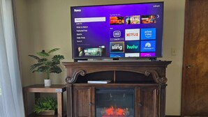 Un televisor sobre un soporte de madera con una chimenea abajo.