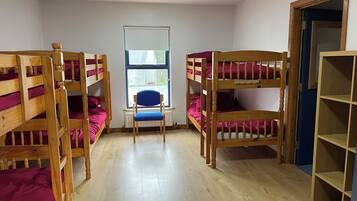 Una habitación con literas, una silla y una ventana.