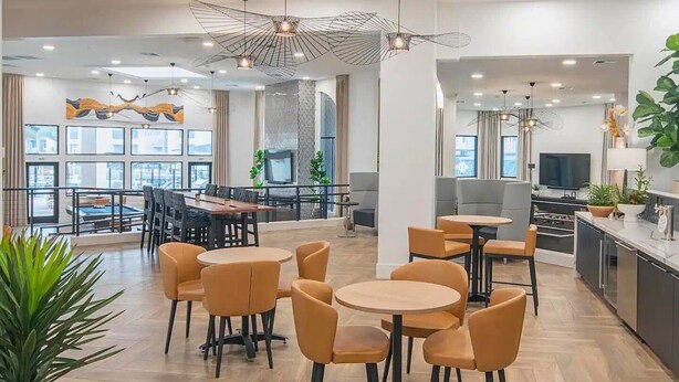 Eine moderne Hotelhalle mit Essbereich, Sitzgelegenheiten und einer Küche.